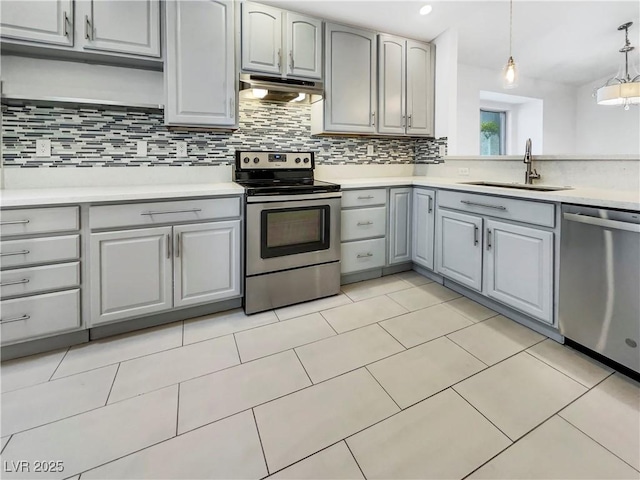kitchen featuring a sink, light countertops, appliances with stainless steel finishes, under cabinet range hood, and gray cabinetry