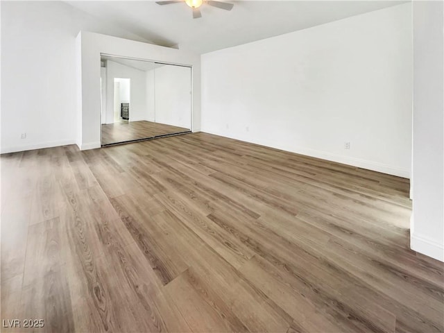unfurnished room with wood finished floors, baseboards, a ceiling fan, and vaulted ceiling