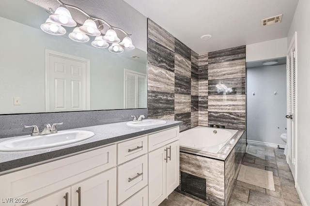 bathroom with a garden tub, visible vents, a sink, and toilet