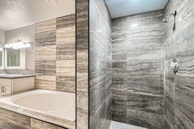 bathroom with tiled shower, vanity, a textured ceiling, and a tub with jets