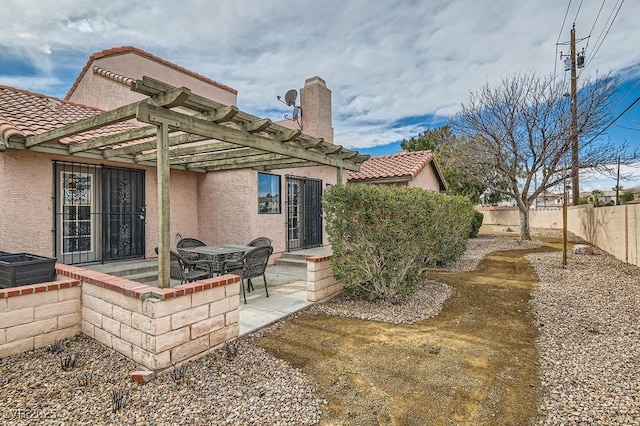 back of property with a patio, stucco siding, a tiled roof, and fence