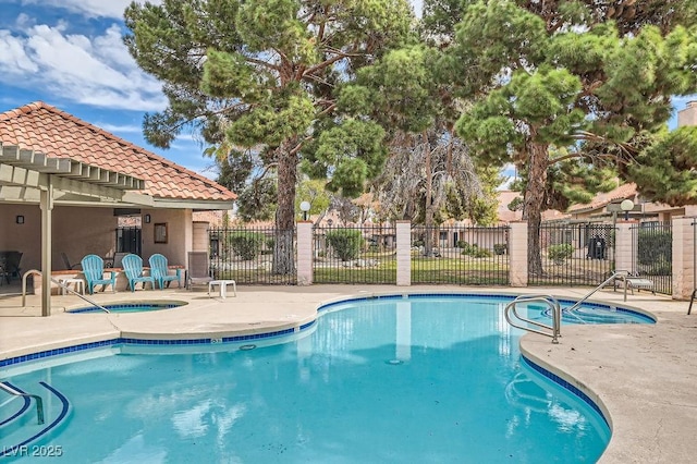 pool featuring a patio area, a community hot tub, and fence