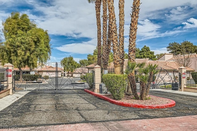 exterior space featuring a gated entry, curbs, and a gate