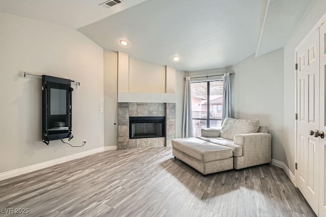 unfurnished living room with wood finished floors, a fireplace, and baseboards