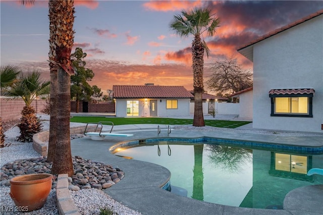 pool at dusk with a fenced in pool, a patio area, and fence