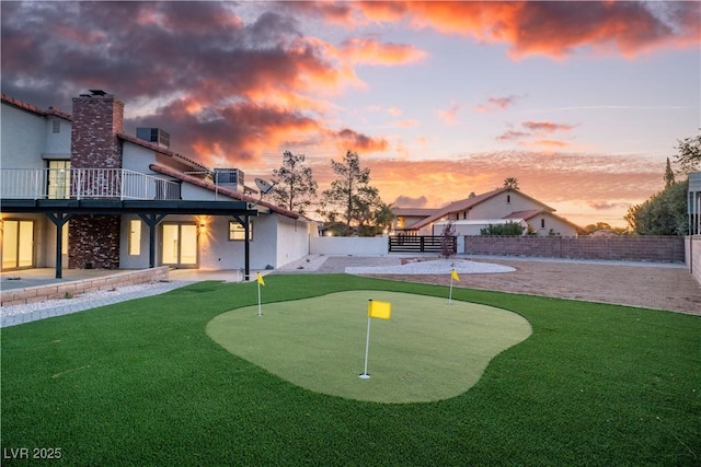 yard at dusk featuring a patio area, fence, and central AC unit
