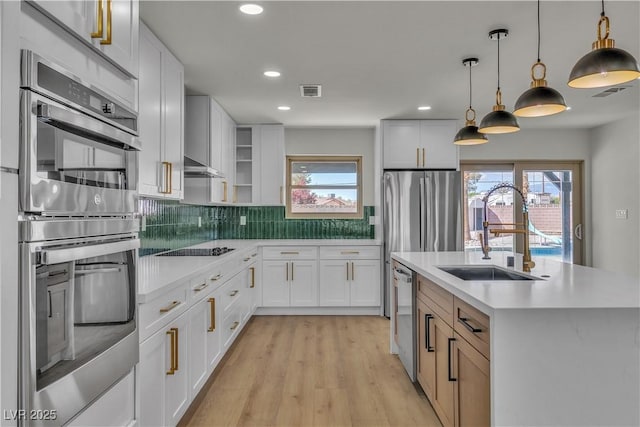 kitchen featuring stainless steel appliances, tasteful backsplash, light countertops, and a sink