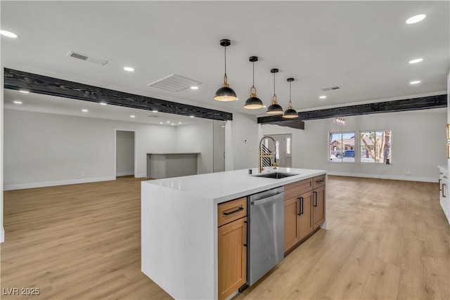 kitchen with visible vents, dishwasher, a sink, open floor plan, and light wood-style floors
