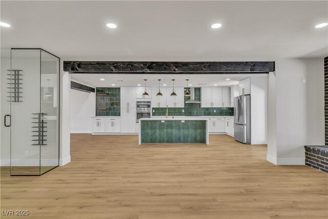 kitchen featuring wall chimney range hood, light wood-style floors, recessed lighting, white cabinetry, and stainless steel appliances