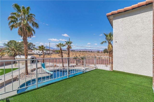 view of yard featuring fence, a fenced in pool, a patio, and a balcony