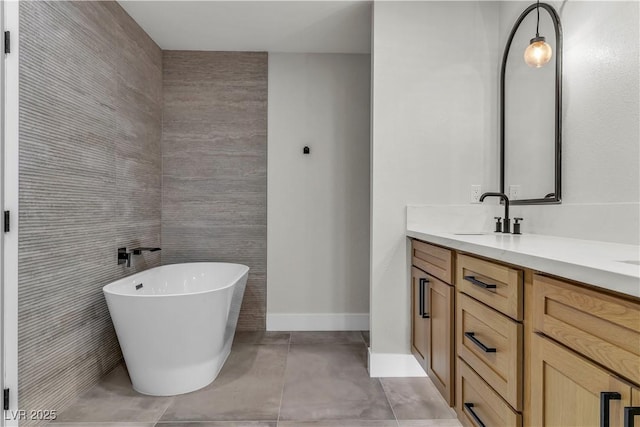 bathroom featuring tile patterned floors, a soaking tub, double vanity, and a sink