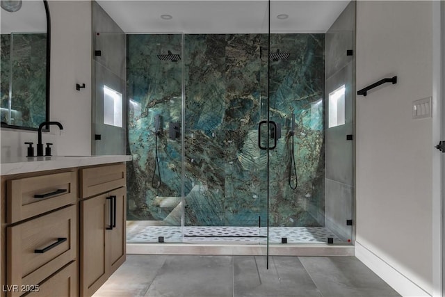 full bath featuring a marble finish shower and vanity