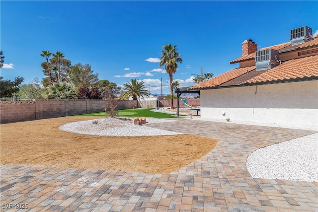 view of yard featuring a patio, central air condition unit, and a fenced backyard