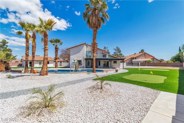 exterior space with stucco siding, a patio, fence, a balcony, and a fenced in pool