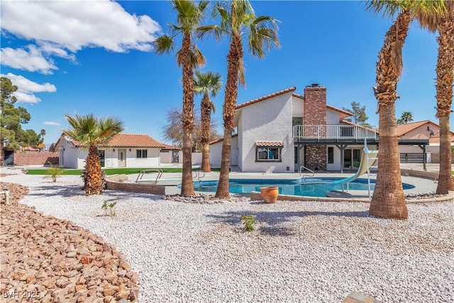 pool featuring a patio area and a water slide