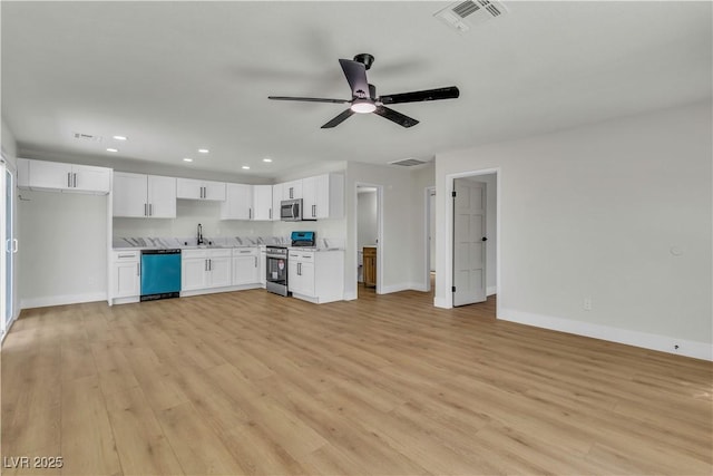 kitchen with visible vents, a sink, stainless steel appliances, open floor plan, and light wood finished floors