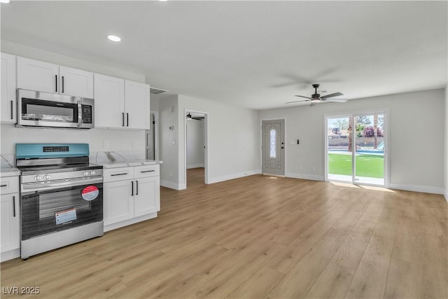 kitchen featuring light wood-style flooring, white cabinetry, a ceiling fan, and stainless steel appliances