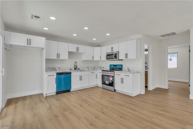 kitchen featuring visible vents, white cabinetry, and appliances with stainless steel finishes