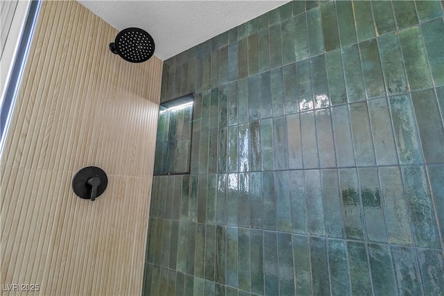 interior details with tiled shower and a textured ceiling