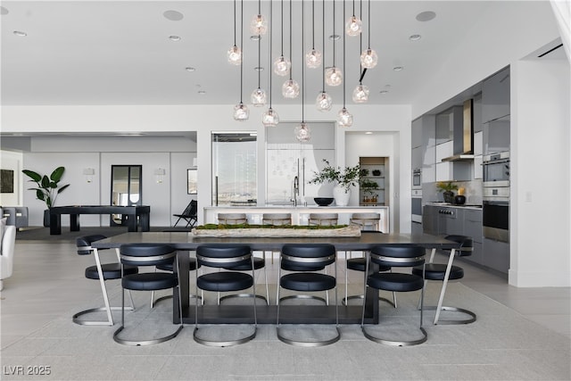 667 Palisade Rim Dr, Henderson, NV 89012 - kitchen featuring gray cabinetry, wall chimney exhaust hood, a sink, and stainless steel double oven