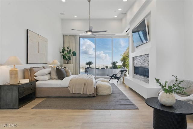 667 Palisade Rim Dr, Henderson, NV 89012 - bedroom featuring a stone fireplace, light wood-type flooring, recessed lighting, access to outside, and a ceiling fan