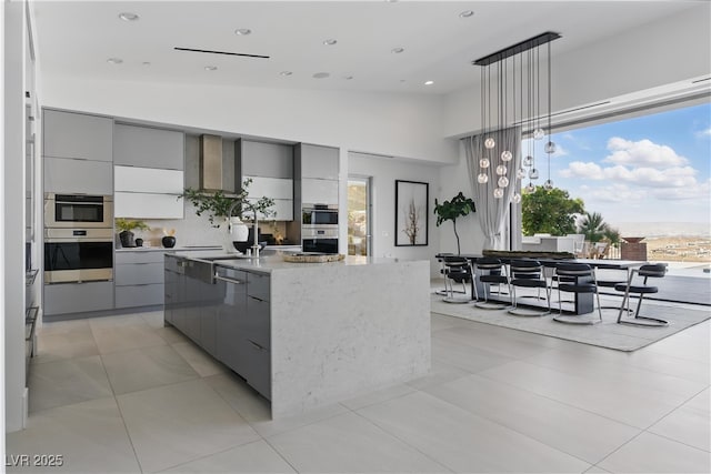 667 Palisade Rim Dr, Henderson, NV 89012 - kitchen with gray cabinets, modern cabinets, hanging light fixtures, a kitchen island with sink, and backsplash