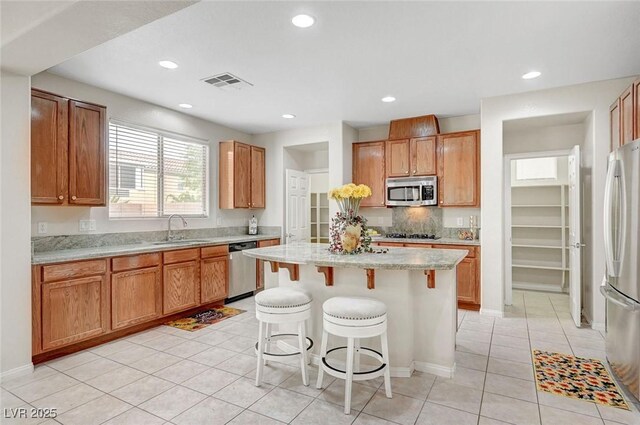 7216 Campolina Ct, Las Vegas, NV 89113 - kitchen featuring a sink, stainless steel appliances, a kitchen bar, visible vents, and a kitchen island