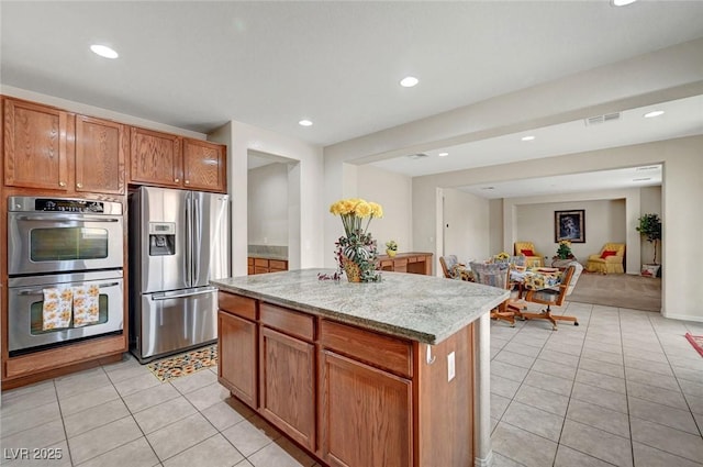 7216 Campolina Ct, Las Vegas, NV 89113 - kitchen with recessed lighting, stainless steel appliances, visible vents, light tile patterned floors, and a kitchen island