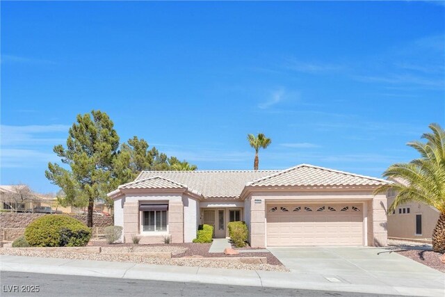 view of front of house with a garage, stucco siding, concrete driveway, and a tile roof