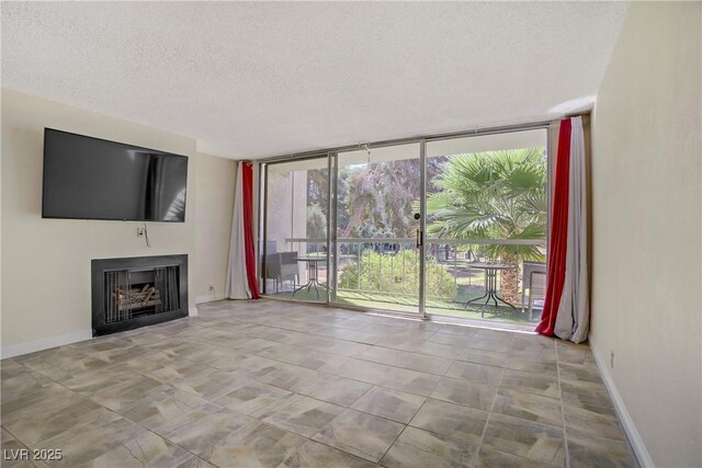 725 N Royal Crest Cir Unit 214, Las Vegas, NV 89169 - unfurnished living room featuring expansive windows, a textured ceiling, baseboards, and a fireplace