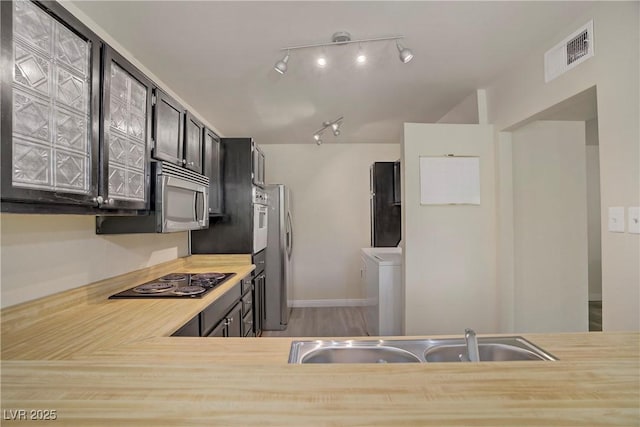 725 N Royal Crest Cir Unit 214, Las Vegas, NV 89169 - kitchen featuring stainless steel appliances, a sink, light countertops, independent washer and dryer, and wood finished floors