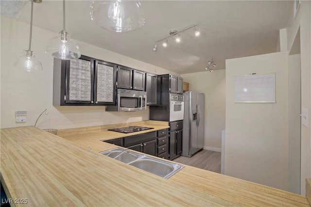 725 N Royal Crest Cir Unit 214, Las Vegas, NV 89169 - kitchen with appliances with stainless steel finishes, a sink, light countertops, pendant lighting, and light wood-style flooring