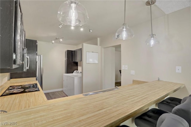 725 N Royal Crest Cir Unit 214, Las Vegas, NV 89169 - kitchen featuring a sink, a kitchen breakfast bar, wood finished floors, freestanding refrigerator, and a peninsula