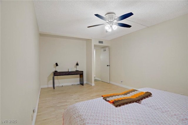725 N Royal Crest Cir Unit 214, Las Vegas, NV 89169 - bedroom featuring light wood-style floors, baseboards, a textured ceiling, and a ceiling fan