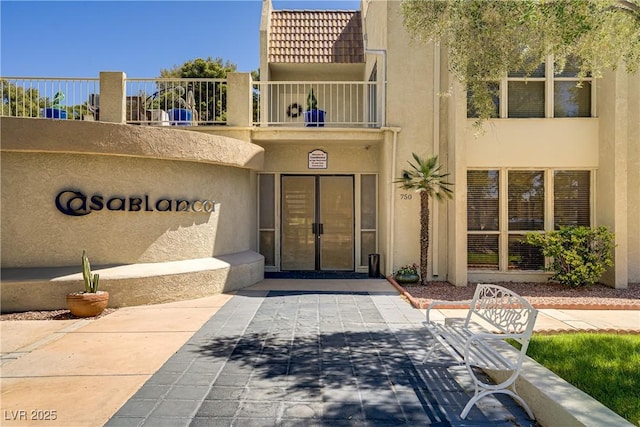 725 N Royal Crest Cir Unit 214, Las Vegas, NV 89169 - view of exterior entry featuring stucco siding, french doors, and a tiled roof