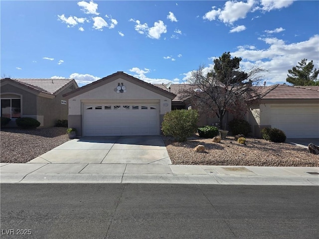 ranch-style house with concrete driveway, a tiled roof, a garage, and stucco siding