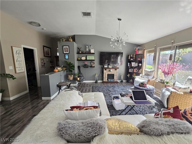 living room with visible vents, wood finished floors, lofted ceiling, baseboards, and a notable chandelier