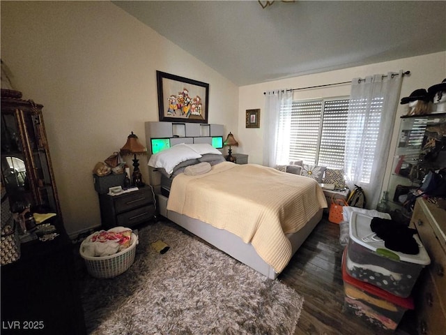 bedroom with vaulted ceiling and wood finished floors