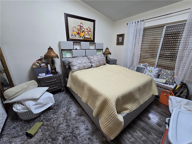bedroom featuring wood finished floors and lofted ceiling