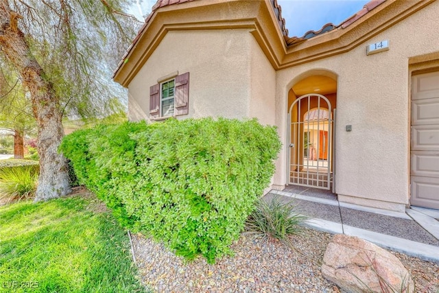 entrance to property with stucco siding and a tile roof