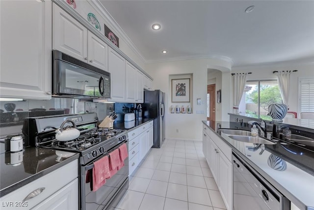 kitchen featuring crown molding, arched walkways, white cabinetry, black appliances, and a sink
