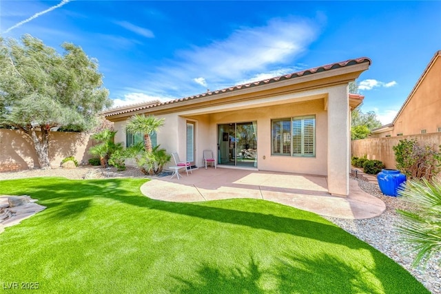 rear view of property with a tiled roof, a fenced backyard, a patio, and stucco siding