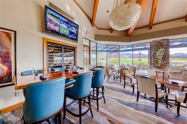 dining space featuring beam ceiling and wood finished floors