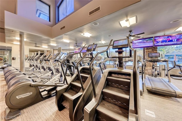 workout area featuring visible vents, ceiling fan, and a towering ceiling