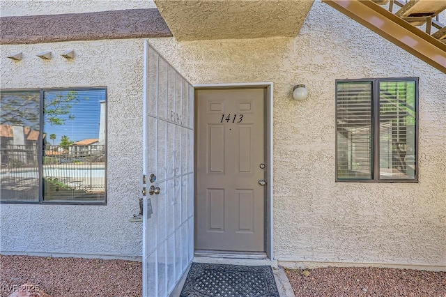 property entrance with stucco siding