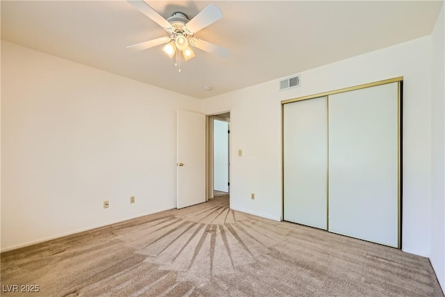 unfurnished bedroom featuring visible vents, a ceiling fan, a closet, and carpet