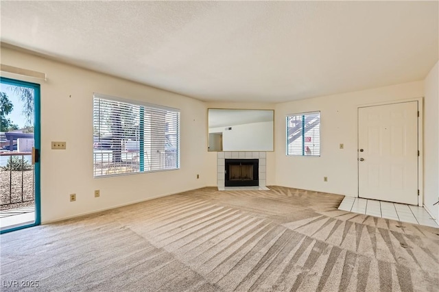 unfurnished living room featuring a tile fireplace and carpet