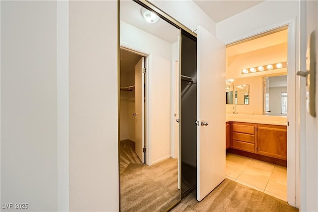interior space featuring tile patterned floors, a walk in closet, and vanity