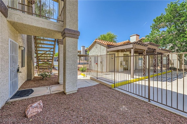 view of gate featuring a patio and stairs