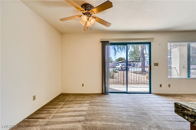 carpeted spare room featuring a ceiling fan